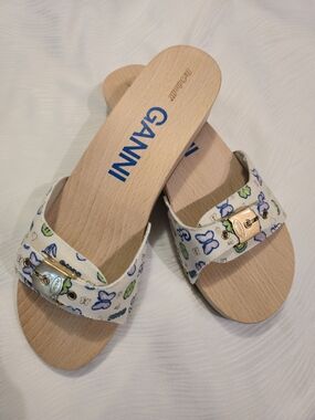 These are GANNI x Dr. Scholl's clogs in a white "kiosk" print with a wooden sole
